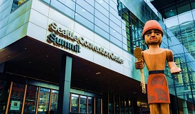 entrance to the Seattle Convention Center Summit Building flanked by a Native American totem pole