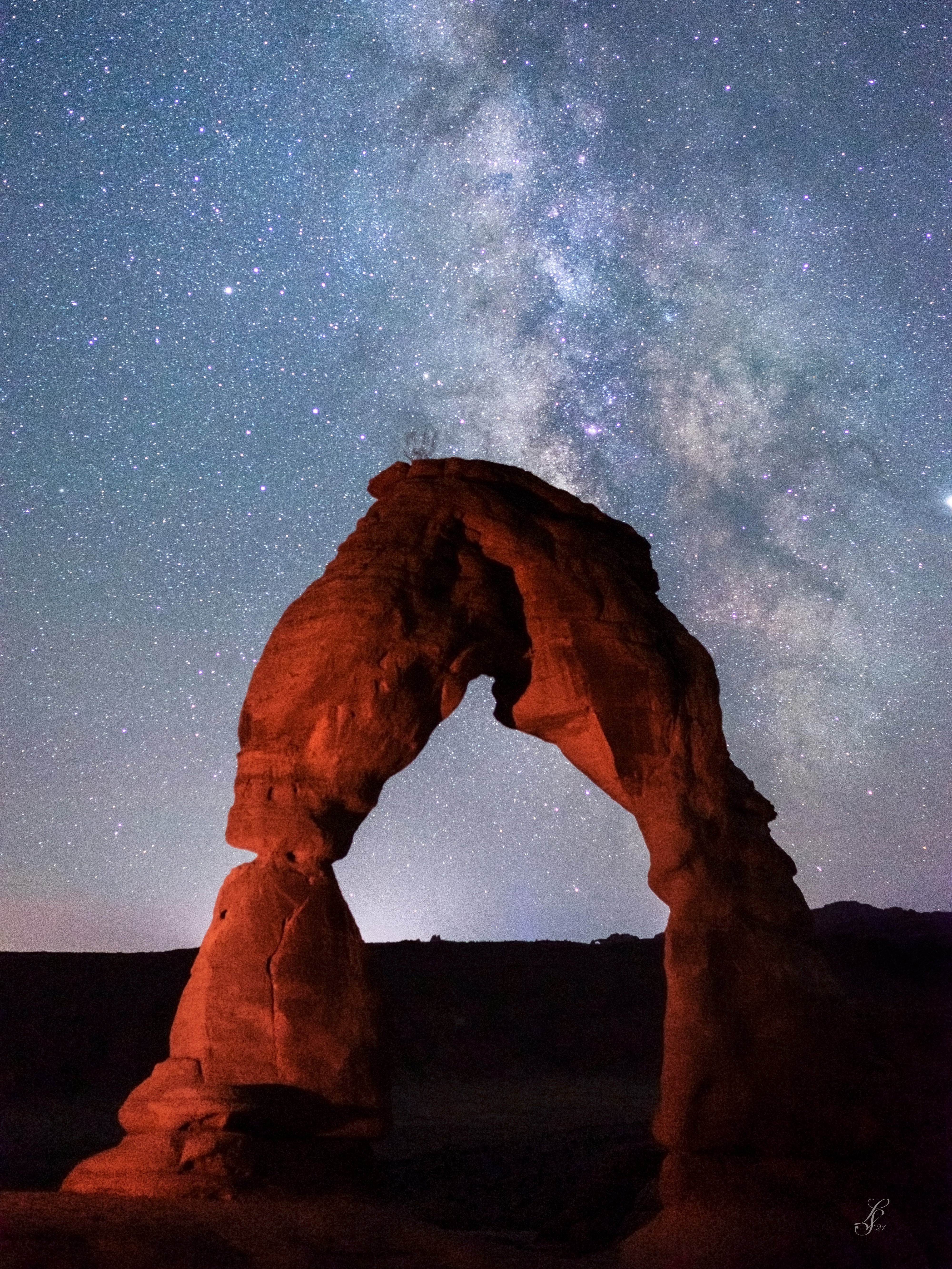 Delicate Arch under a starry night sky with the Milky Way visible, located in Arches National Park, Utah